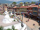 Kathmandu Boudhanath 16 End OF Boudhanath Kora With Shops Circling The Stupa Smaller white stupas, and more Tibetan Buddhist shops flank the east side of Boudhanath Stupa near Kathmandu.